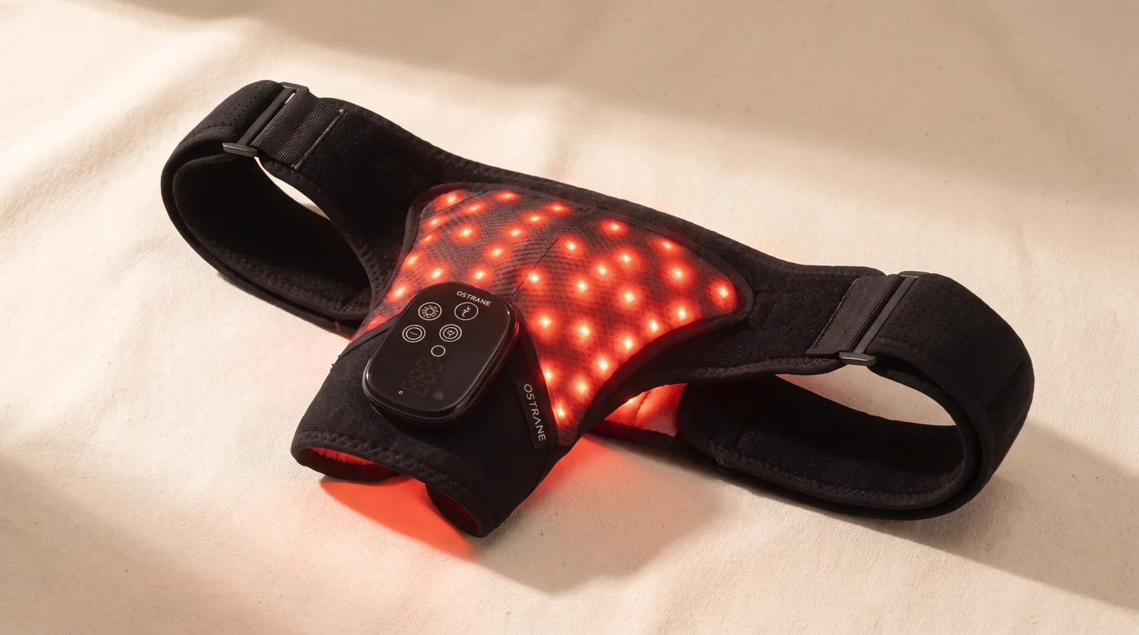 The Ostrane Ember red light and infrared shoulder wrap laid flat, LEDs glowing